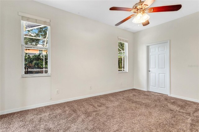 spare room featuring ceiling fan, plenty of natural light, and carpet floors