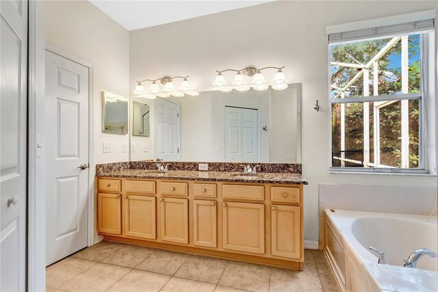 bathroom featuring tiled bath, tile patterned flooring, and vanity