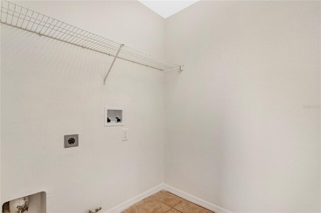 washroom with hookup for an electric dryer, washer hookup, light tile patterned flooring, and hookup for a gas dryer