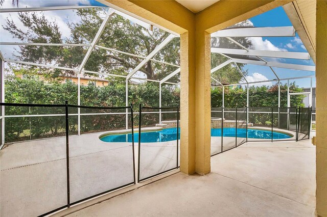 view of swimming pool featuring a lanai and a patio area