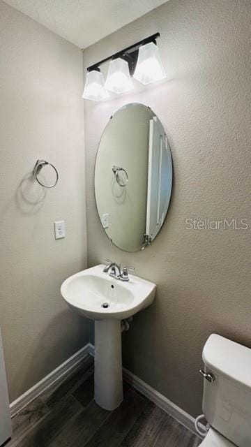 bathroom with hardwood / wood-style floors and toilet