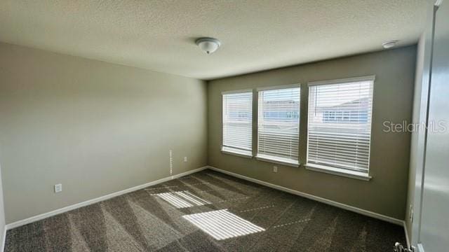 carpeted spare room with a textured ceiling