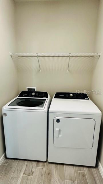 washroom featuring washer and clothes dryer and light wood-type flooring