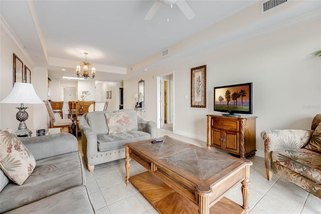 tiled living room with a tray ceiling and ceiling fan with notable chandelier