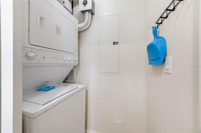 washroom featuring stacked washer / drying machine and electric panel