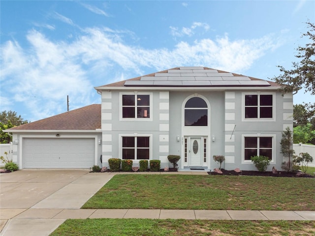 view of front of house with solar panels, a front yard, and a garage