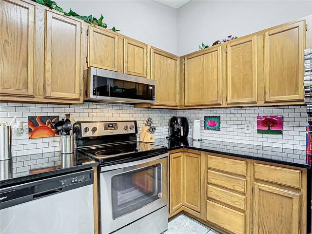 kitchen with stainless steel appliances, light brown cabinets, and backsplash