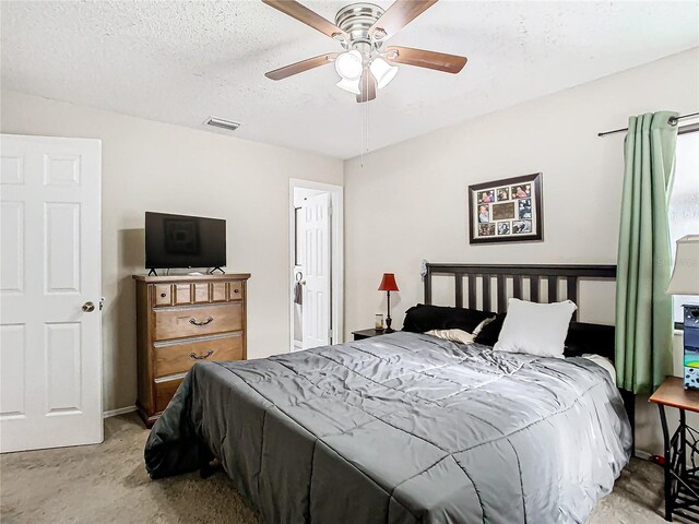 carpeted bedroom featuring a textured ceiling and ceiling fan