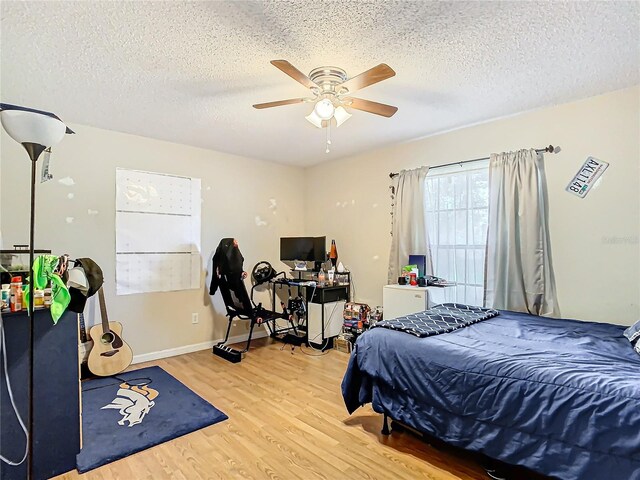 bedroom featuring a textured ceiling, ceiling fan, and light hardwood / wood-style floors