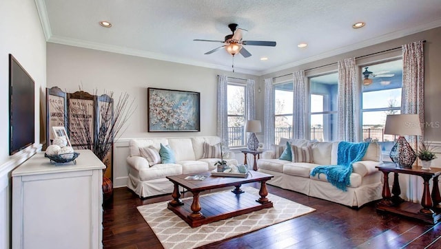 living room with crown molding, dark wood-type flooring, a wealth of natural light, and ceiling fan