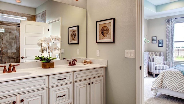 bathroom with tiled shower and vanity