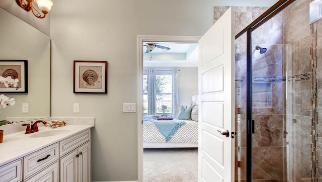 bathroom featuring vanity, a raised ceiling, an enclosed shower, and ceiling fan