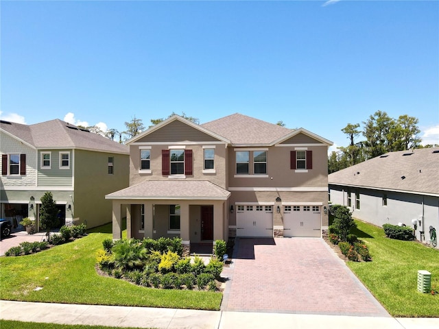 view of front of house featuring a garage, roof with shingles, decorative driveway, stucco siding, and a front yard