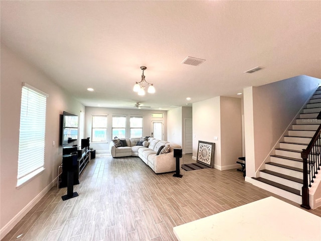 living room with visible vents, baseboards, stairway, light wood-style floors, and recessed lighting