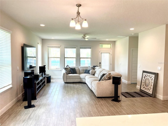 living area featuring baseboards, ceiling fan, recessed lighting, and light wood-style floors