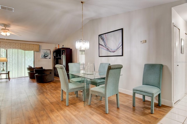 dining room with lofted ceiling, ceiling fan with notable chandelier, and light hardwood / wood-style floors