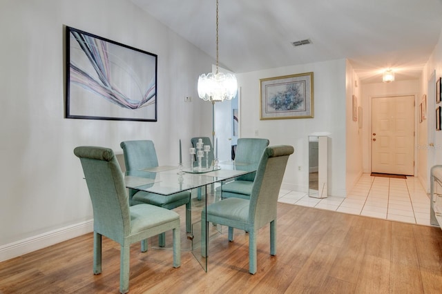 dining room featuring lofted ceiling and light hardwood / wood-style flooring