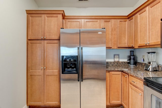 kitchen with stainless steel appliances and dark stone countertops