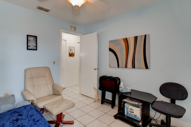 living area featuring light tile patterned floors and ceiling fan