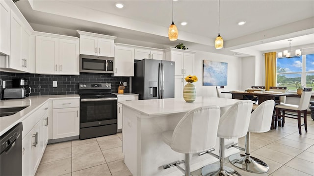 kitchen with pendant lighting, appliances with stainless steel finishes, and white cabinetry