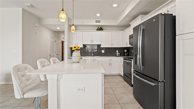 kitchen with a kitchen breakfast bar, a kitchen island, electric range, stainless steel refrigerator with ice dispenser, and white cabinets