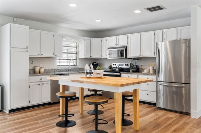 kitchen featuring white cabinetry and appliances with stainless steel finishes