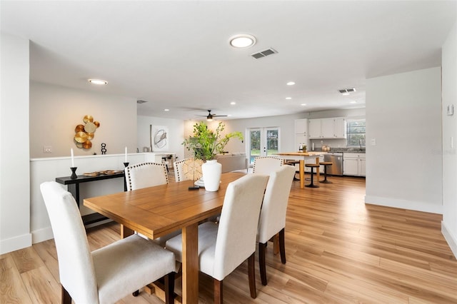 dining room with ceiling fan, sink, and light hardwood / wood-style floors