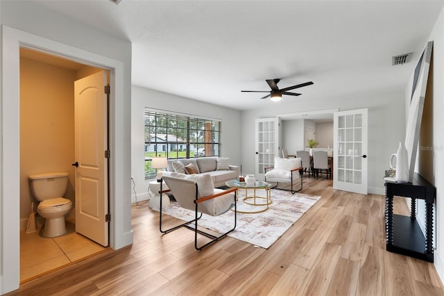 living room with ceiling fan, light hardwood / wood-style flooring, and french doors