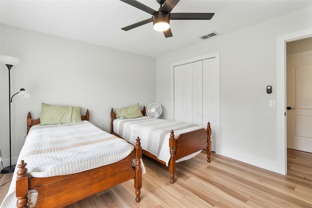 bedroom featuring light hardwood / wood-style floors, ceiling fan, and a closet