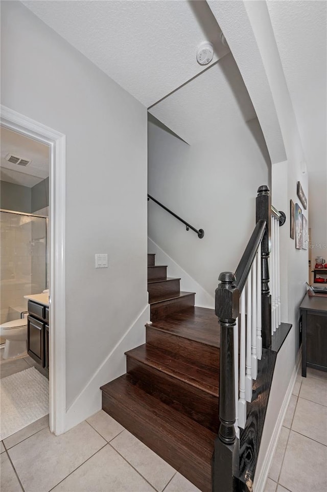 stairs featuring tile patterned flooring