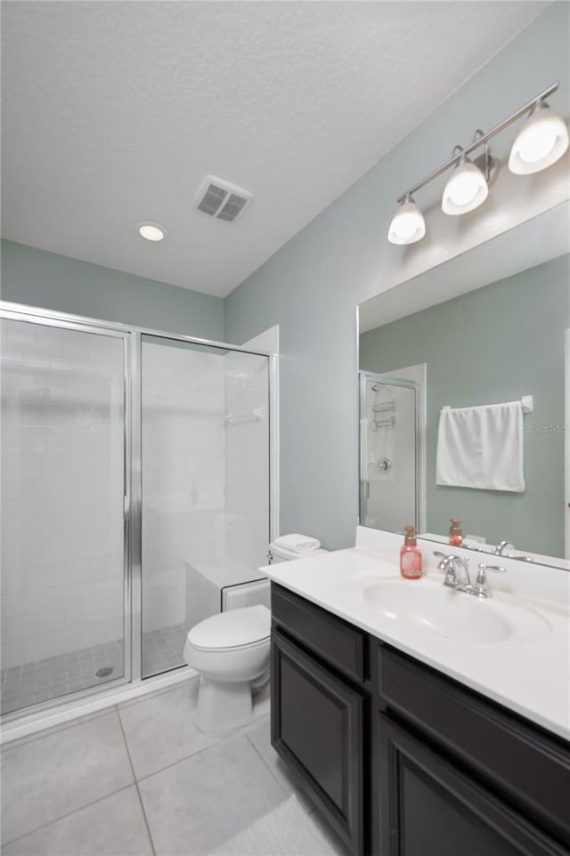 bathroom with walk in shower, tile patterned floors, toilet, a textured ceiling, and vanity