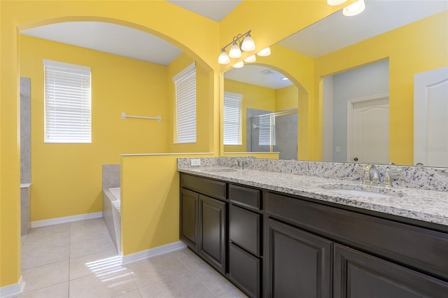 bathroom with tile patterned flooring, vanity, and separate shower and tub