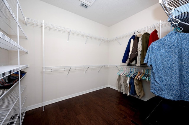 walk in closet with dark hardwood / wood-style flooring