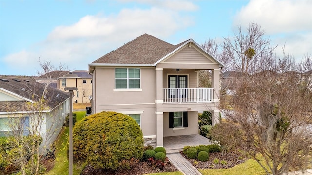 view of front of home with a balcony, ceiling fan, and a patio area