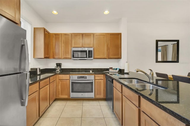 kitchen featuring dark stone counters, kitchen peninsula, sink, appliances with stainless steel finishes, and light tile patterned flooring