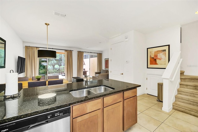 kitchen featuring dark stone countertops, dishwasher, sink, hanging light fixtures, and light tile patterned flooring