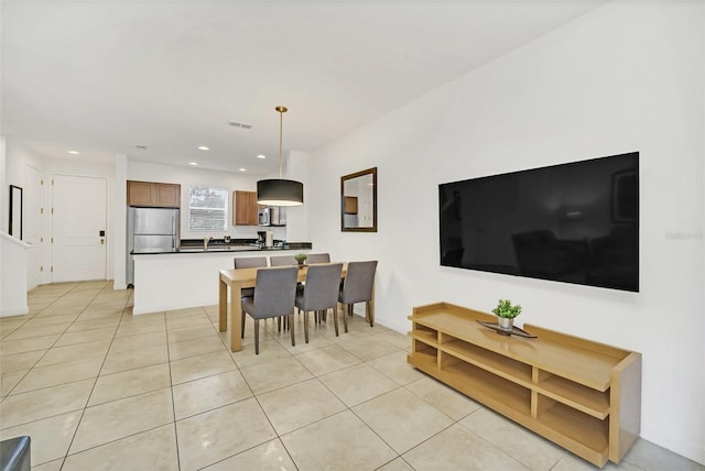 living room featuring sink and light tile patterned floors