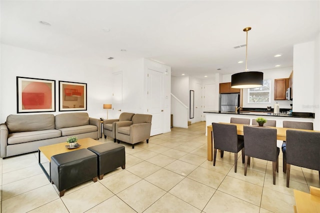 living room featuring sink and light tile patterned floors