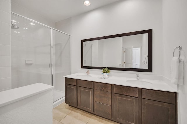 bathroom featuring vanity, a shower with shower door, and tile patterned flooring