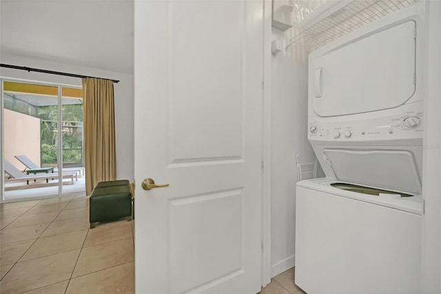 laundry area featuring light tile patterned floors and stacked washer / drying machine