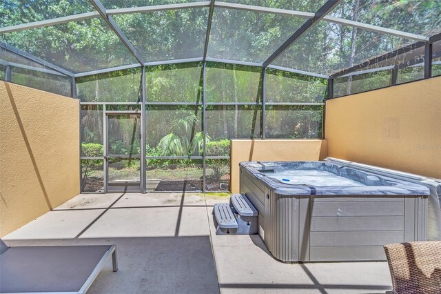 view of patio / terrace with glass enclosure and a hot tub