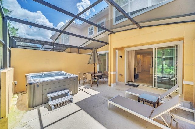 view of patio / terrace with a lanai and a hot tub