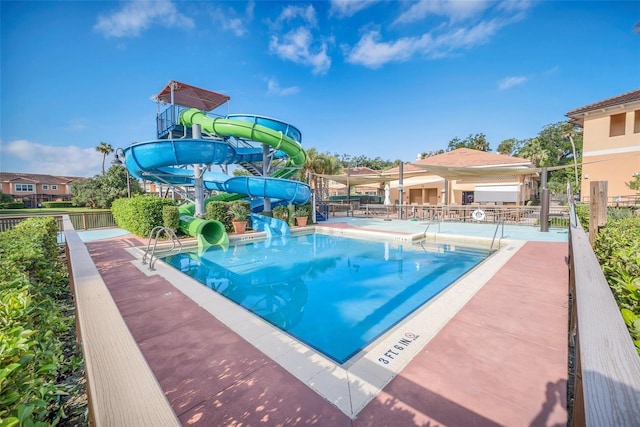 view of swimming pool featuring a water slide and a patio