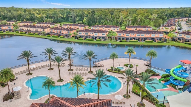 view of pool with a water view, a water slide, and a patio area