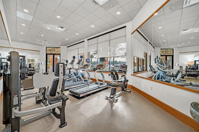 gym featuring a healthy amount of sunlight and a drop ceiling