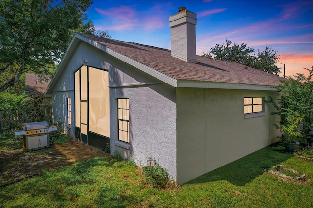 property exterior at dusk with a yard