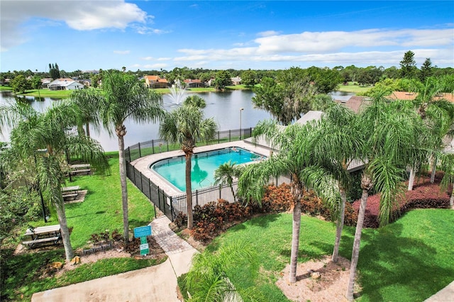 view of swimming pool featuring a water view and a lawn