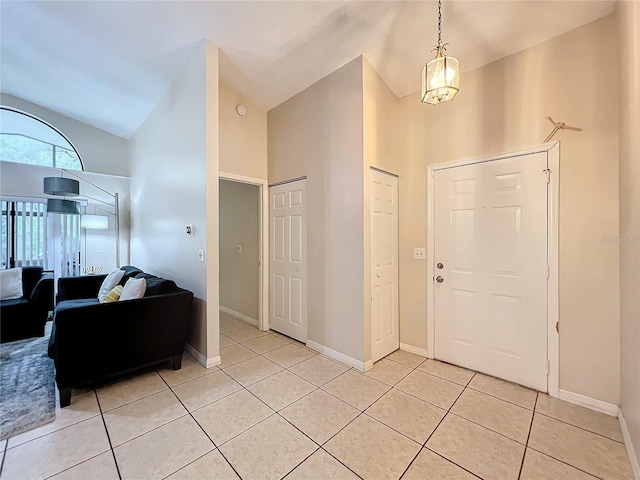 tiled foyer entrance with high vaulted ceiling and a chandelier