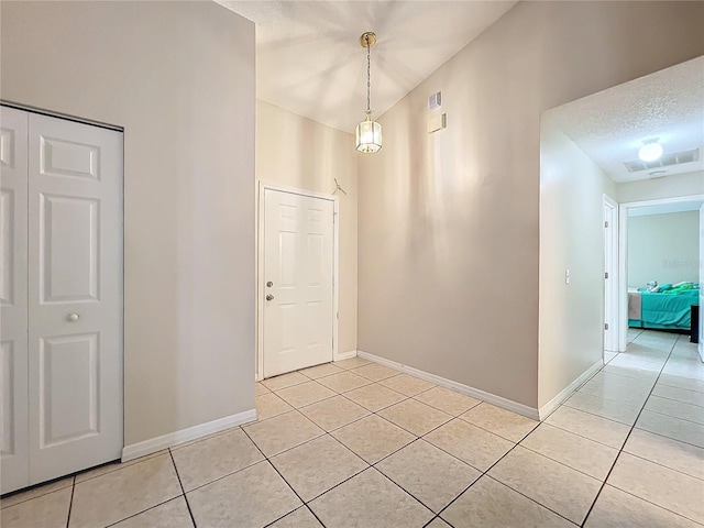 tiled entryway with a textured ceiling