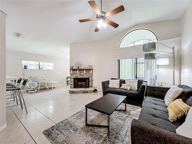 tiled living room featuring a fireplace, vaulted ceiling, and ceiling fan